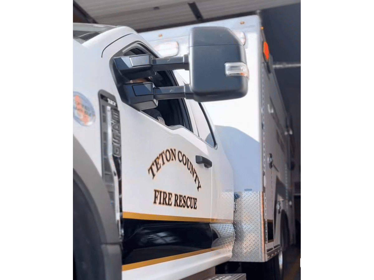 Teton County Fire Rescue ambulance parked in an open station bay, the agency's name lettered on the door